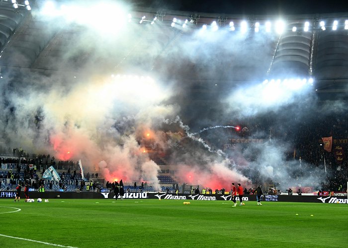 Shocking Club Roma star hit with beer bottle as fans launch flares at each other ... photo
